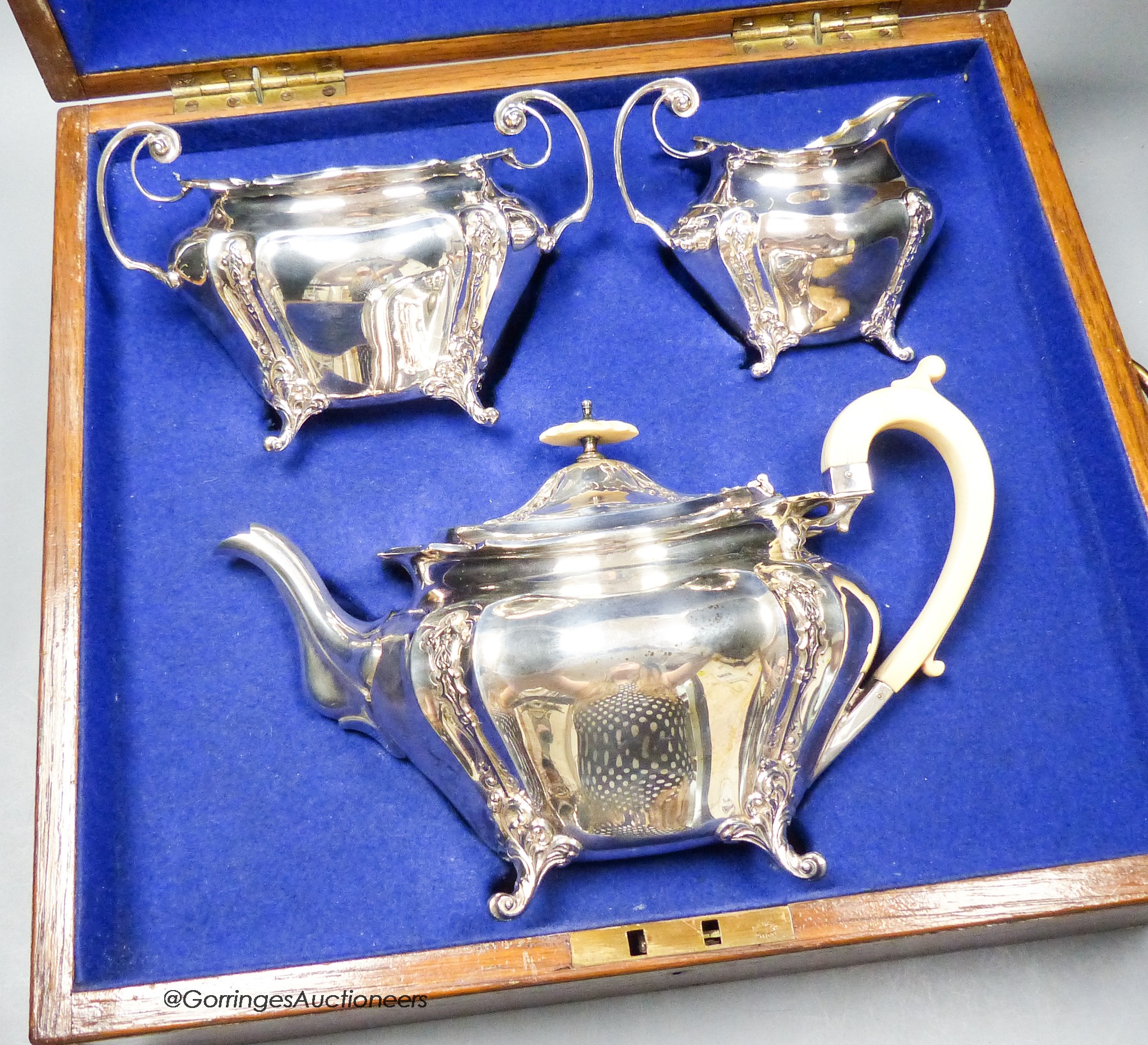 An oak cased Edwardian silver three piece tea set, James Dixon & Sons, Sheffield, 1904, gross weight 33oz.